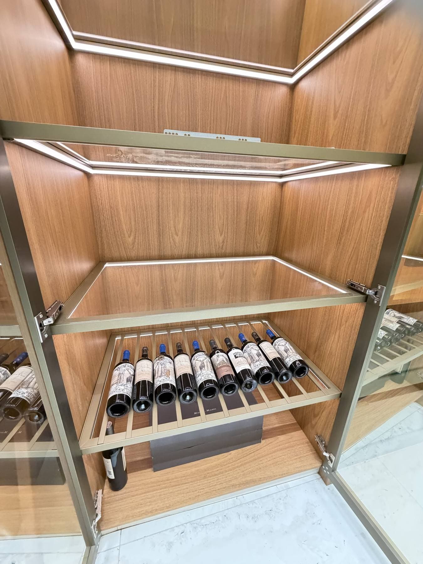 Adega com prateleiras de freijó para garrafas de vinho e estrutura de aço
